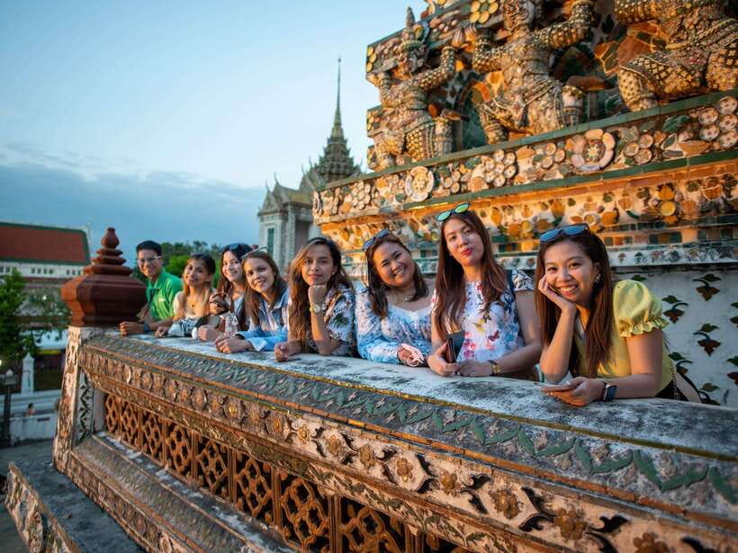 Bangkok: Evening Tour with Wat Arun, Wat Pho & Tuk Tuk Ride - Crossing by ferry to Wat Arun: the riverfront view that changes with the light