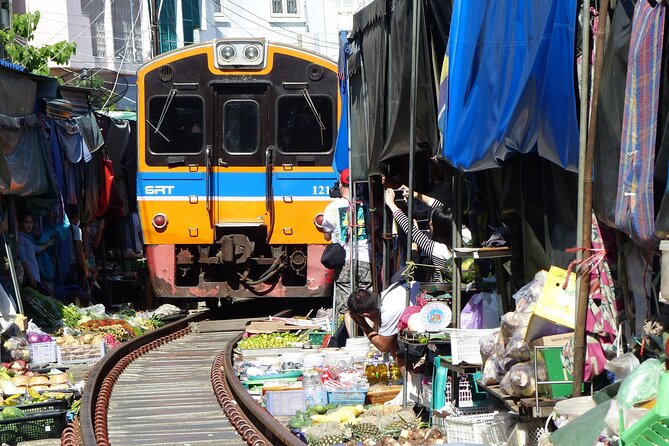 Bangkok: Floating Market and Train Tour with Guide in Spanish and English - Stop 2: Mae Klong Railway Market (Hoop Rom Market) and the stop-start train drama
